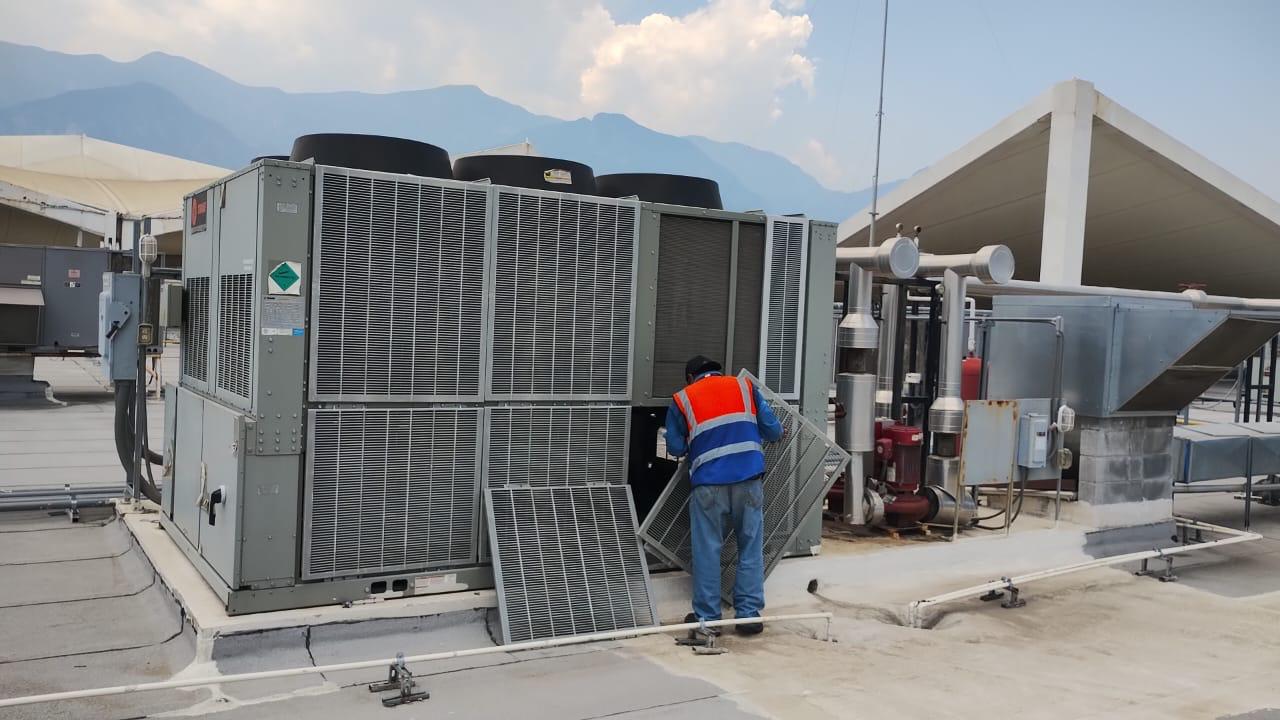 Personal técnico realizando mantenimiento en equipo de climatización industrial